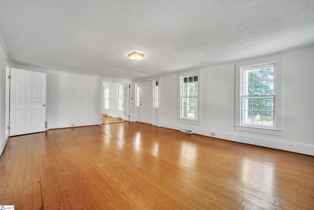 unfurnished living room featuring visible vents, baseboards, and wood-type flooring