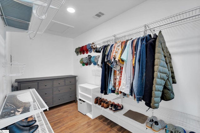 spacious closet featuring visible vents, attic access, and wood finished floors