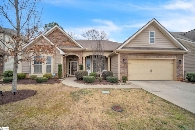 view of front of house with stone siding, a front lawn, an attached garage, and driveway