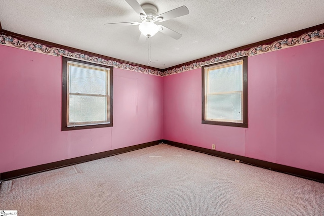 empty room with baseboards, a textured ceiling, a ceiling fan, and carpet