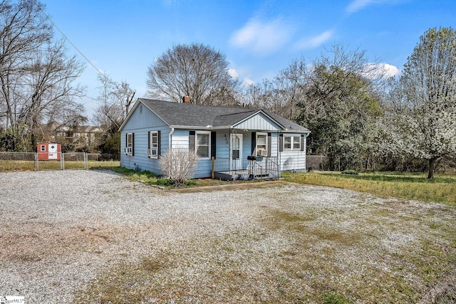 view of front of property with covered porch, a chimney, roof with shingles, and fence