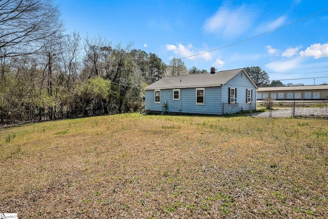 rear view of property with a lawn and fence