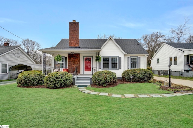 view of front of house featuring a chimney, a porch, a detached carport, and a front yard