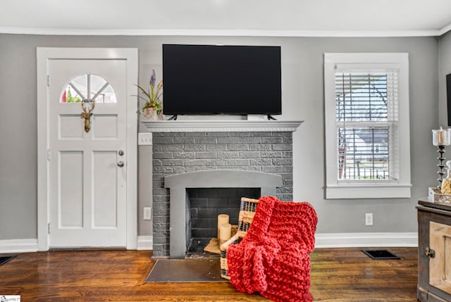 living area featuring visible vents, a fireplace, baseboards, and wood finished floors