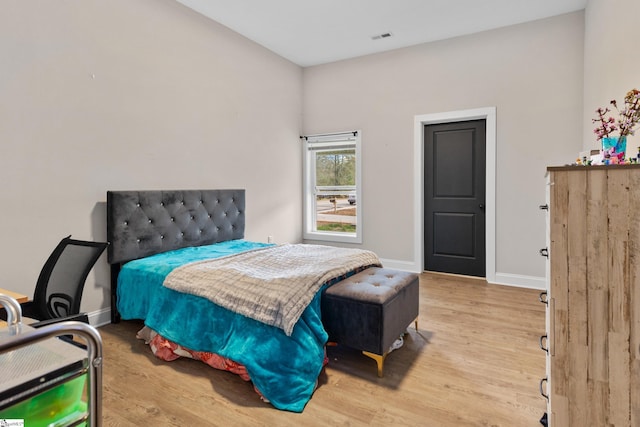 bedroom featuring visible vents, baseboards, and wood finished floors