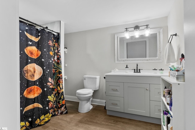 full bathroom featuring toilet, curtained shower, wood finished floors, baseboards, and vanity