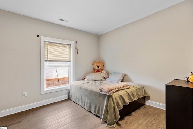 bedroom featuring visible vents, wood finished floors, and baseboards