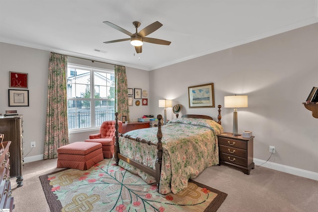 carpeted bedroom featuring visible vents, baseboards, ornamental molding, and a ceiling fan