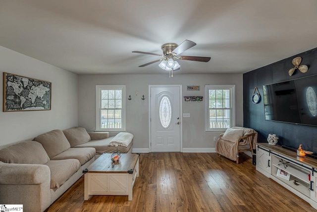 living room with baseboards, wood-type flooring, and ceiling fan