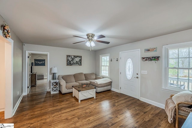 living area featuring wood finished floors, baseboards, and ceiling fan