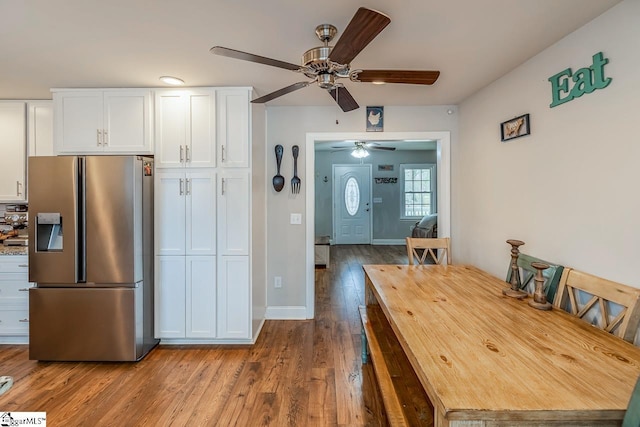 dining room featuring wood finished floors, baseboards, and ceiling fan