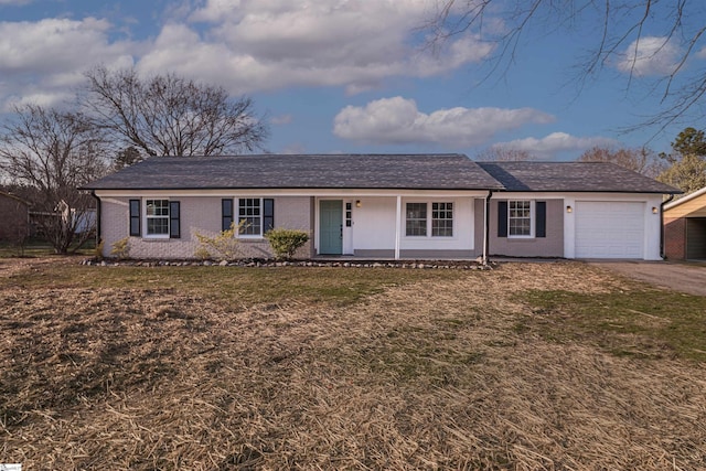 ranch-style house with a front yard, an attached garage, and brick siding