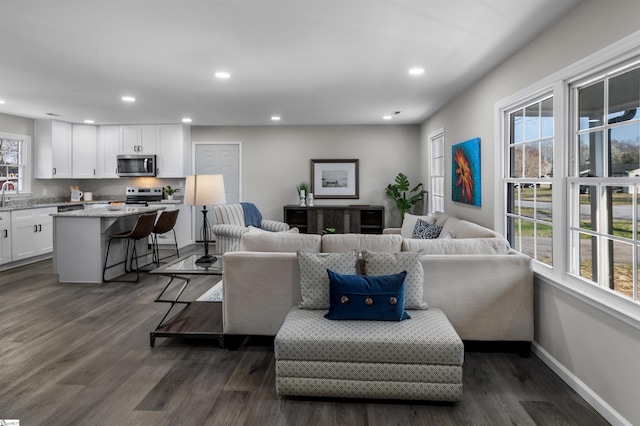 living room featuring recessed lighting, baseboards, and dark wood finished floors