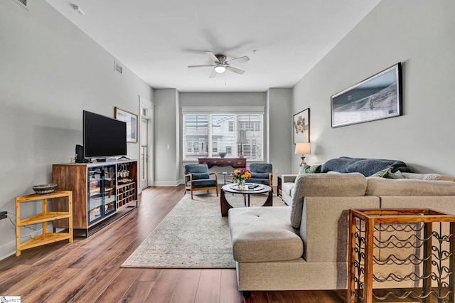 living room with visible vents, baseboards, a ceiling fan, and wood finished floors