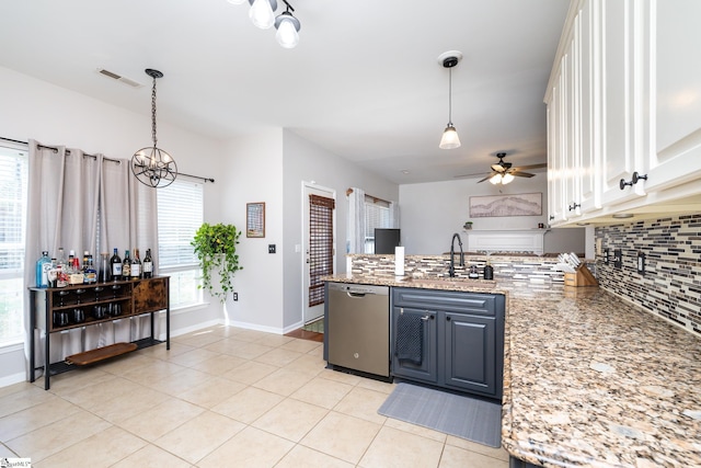 kitchen featuring visible vents, a sink, tasteful backsplash, stainless steel dishwasher, and a peninsula