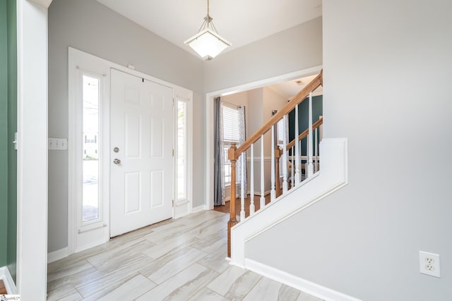 entryway with a wealth of natural light, baseboards, and stairs