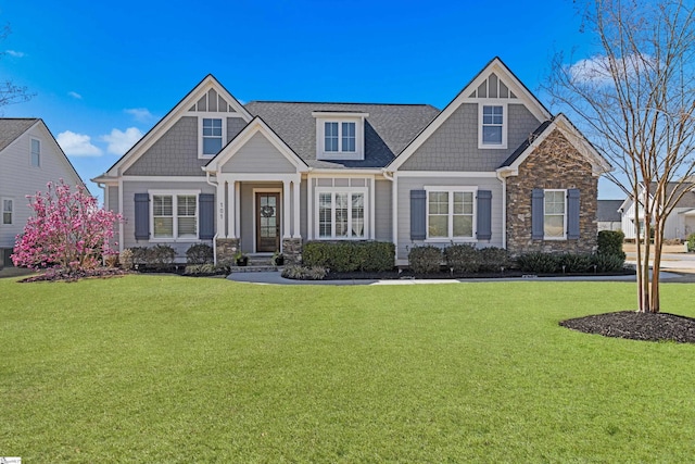 craftsman inspired home featuring stone siding and a front lawn