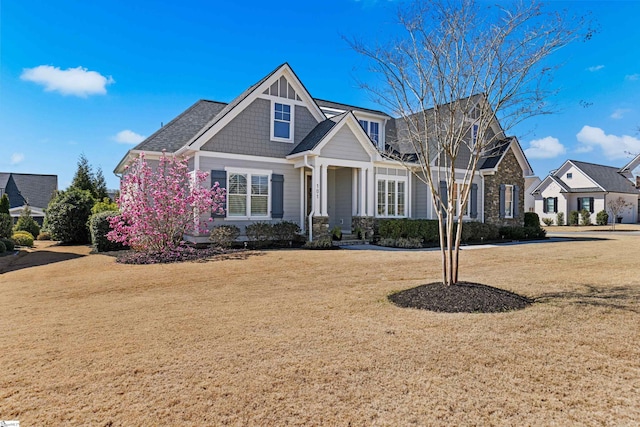 view of front of home with stone siding and a front lawn