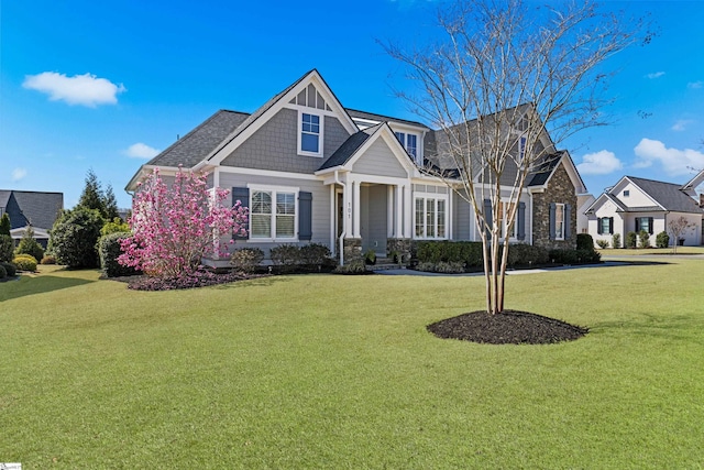 view of front of property with a front yard and stone siding