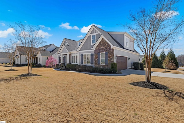 view of front of house with a garage, stone siding, concrete driveway, and a front lawn