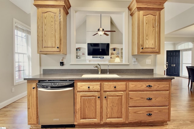 kitchen featuring dark countertops, light wood finished floors, dishwasher, a ceiling fan, and a sink