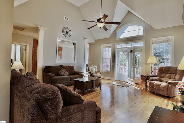 living area with ceiling fan, high vaulted ceiling, visible vents, and light wood-type flooring