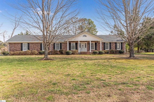 view of front of house featuring brick siding, a porch, and a front lawn