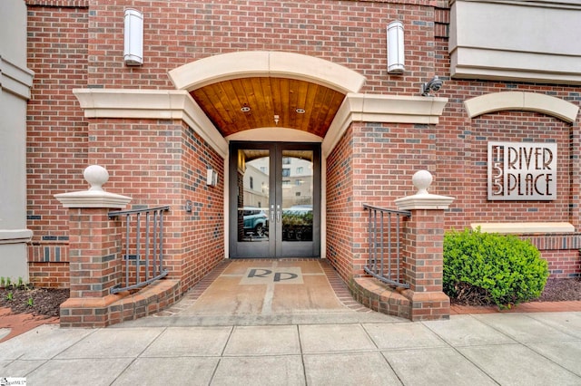 doorway to property featuring french doors and brick siding