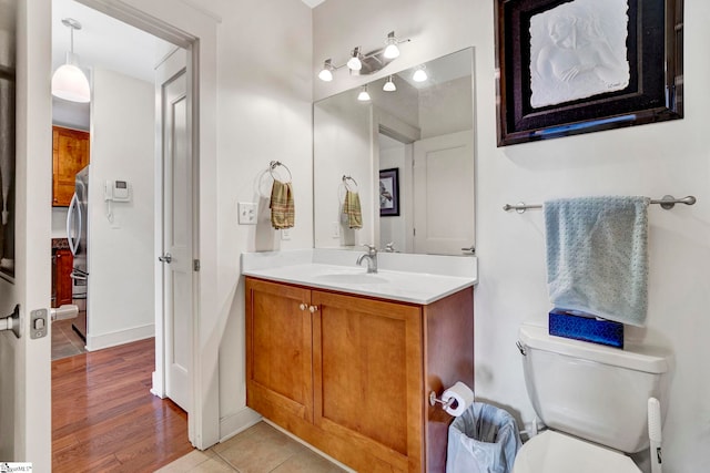 bathroom with vanity, toilet, and wood finished floors