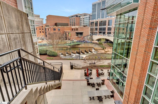 surrounding community featuring a patio area and a water view