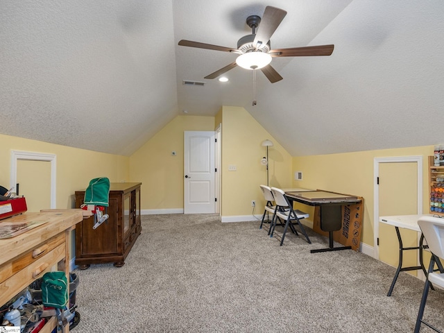 home office with visible vents, a textured ceiling, carpet flooring, lofted ceiling, and ceiling fan