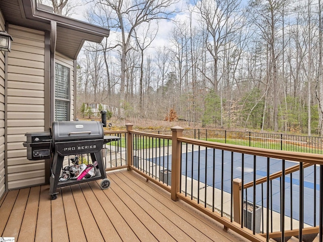 deck with a fenced in pool, area for grilling, and a fenced backyard