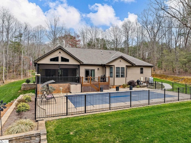 view of pool with a wooden deck, a sunroom, a lawn, and a patio area