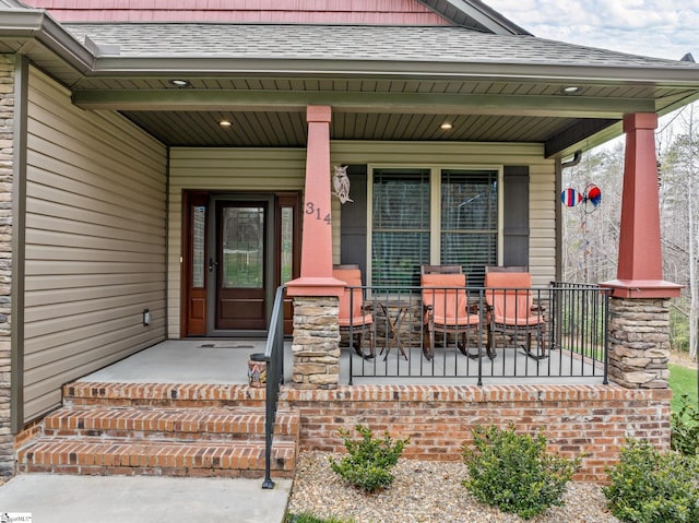 property entrance featuring a porch and a shingled roof