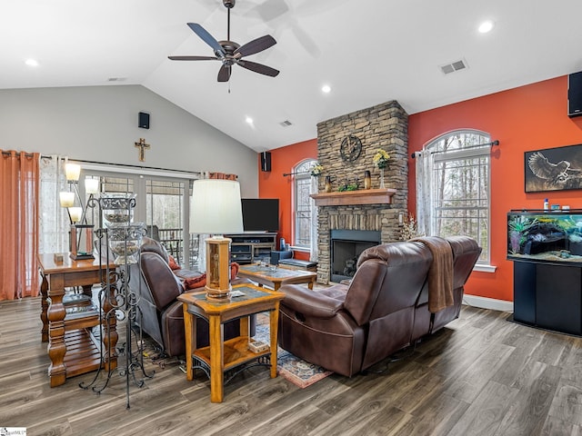 living room featuring visible vents, a large fireplace, ceiling fan, vaulted ceiling, and wood finished floors