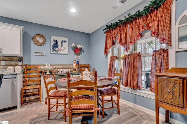 dining room featuring baseboards, visible vents, and light wood-type flooring