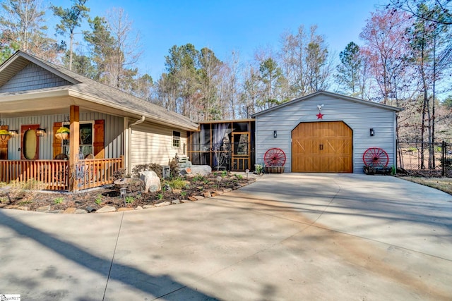 view of front of home featuring an outbuilding, covered porch, and driveway