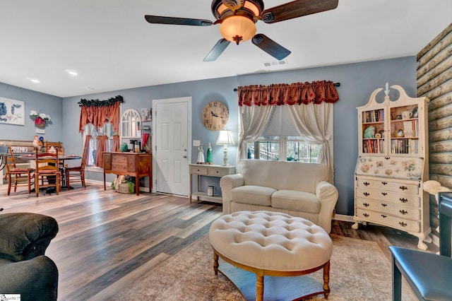 living area with wood finished floors, baseboards, and ceiling fan