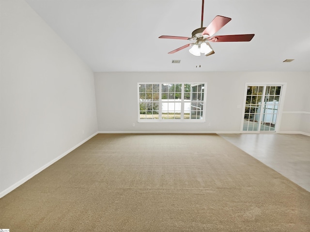 unfurnished room with baseboards, visible vents, a ceiling fan, and carpet