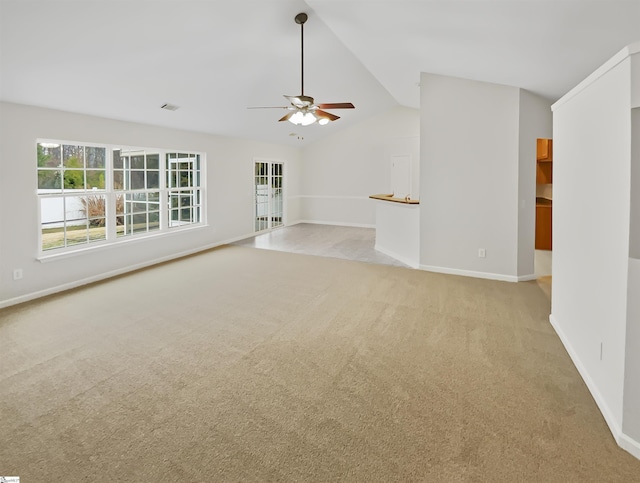 unfurnished living room with visible vents, baseboards, ceiling fan, vaulted ceiling, and light carpet