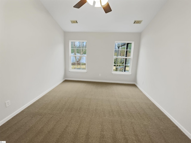 carpeted spare room featuring visible vents, baseboards, lofted ceiling, and a ceiling fan