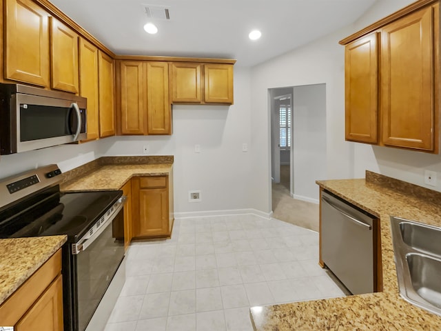 kitchen featuring light stone countertops, brown cabinetry, visible vents, recessed lighting, and appliances with stainless steel finishes