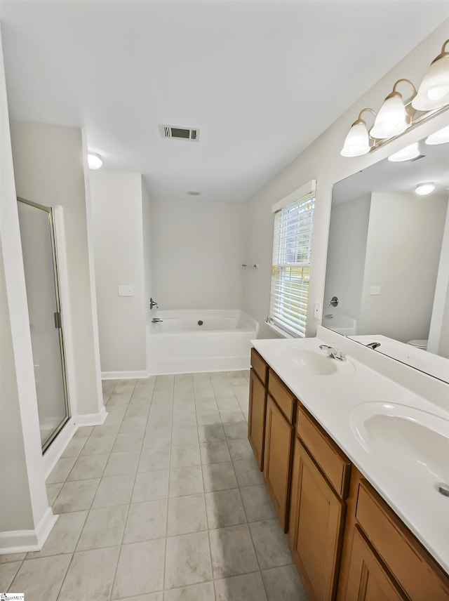 bathroom with visible vents, double vanity, a stall shower, a sink, and a garden tub