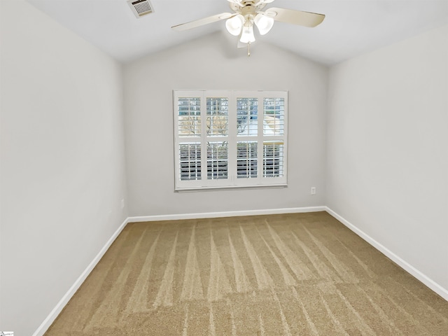 spare room with a ceiling fan, visible vents, baseboards, lofted ceiling, and carpet flooring