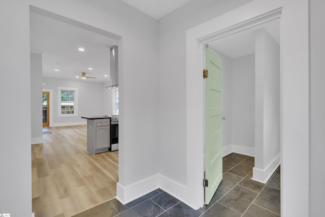 corridor with tile patterned floors, recessed lighting, and baseboards