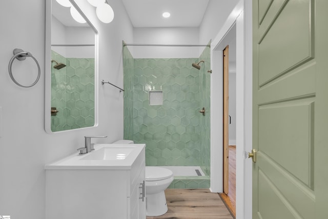 bathroom with vanity, toilet, wood finished floors, and a shower stall