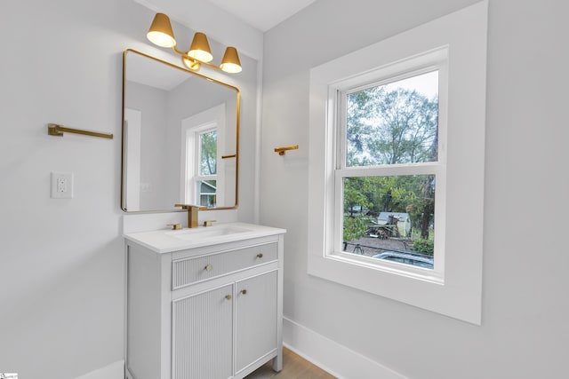 bathroom featuring vanity, a healthy amount of sunlight, and baseboards