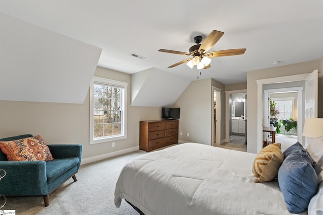 carpeted bedroom featuring visible vents, ensuite bathroom, baseboards, ceiling fan, and vaulted ceiling