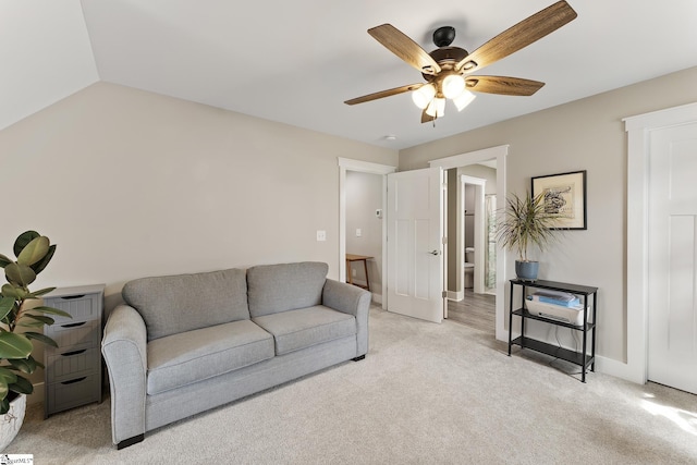 living area featuring baseboards, lofted ceiling, light colored carpet, and ceiling fan