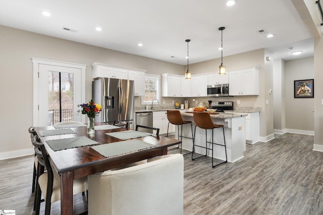 dining space featuring recessed lighting, wood finished floors, visible vents, and baseboards